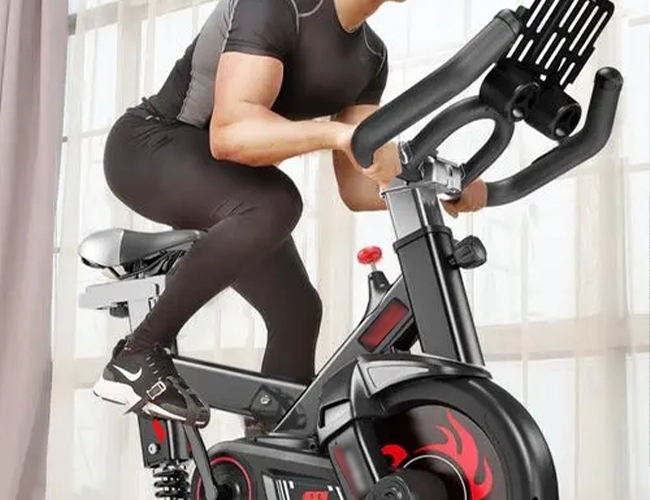 He is riding an exercise bike