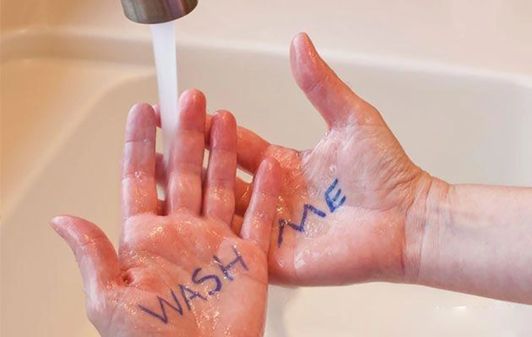 Washing hands repeatedly, with the words "WASH ME" on the hands.