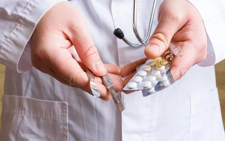 Doctor holding treatment drugs and scalpels.