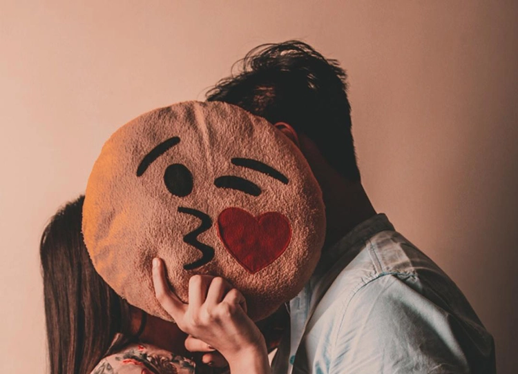 The couple used a round pillow to block their kissing moments.