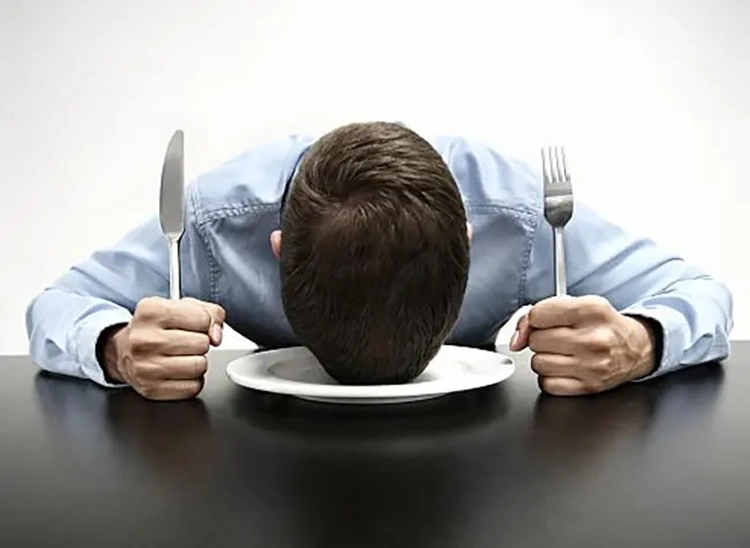 He is so hungry that he is lying on the table.