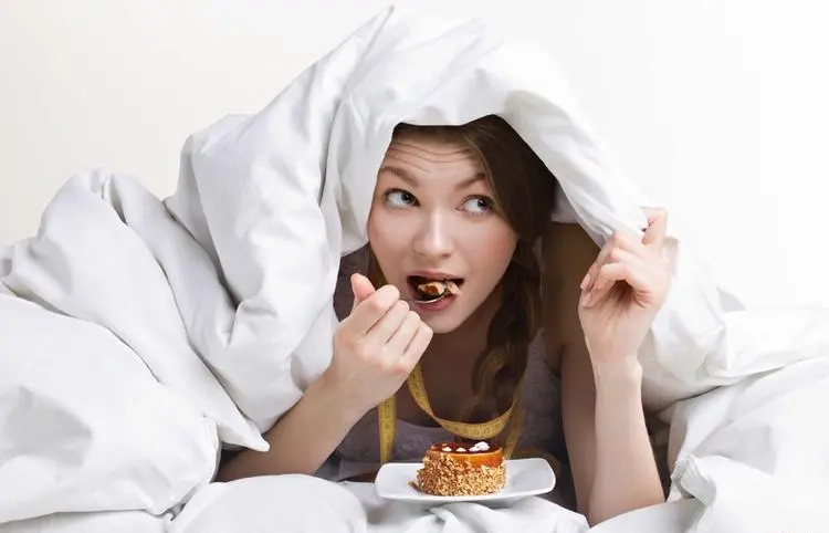 The girl secretly ate desserts in bed.