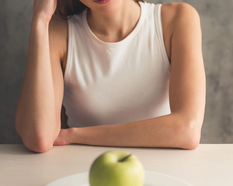 She has no interest in the apple in front of her because of anorexia.