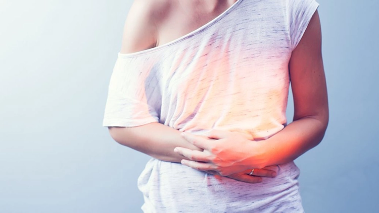 The young woman covered her lower abdomen with both hands because she was uncomfortable.