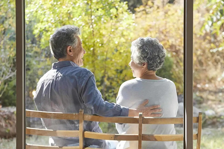 An elderly couple is basking in the sun.