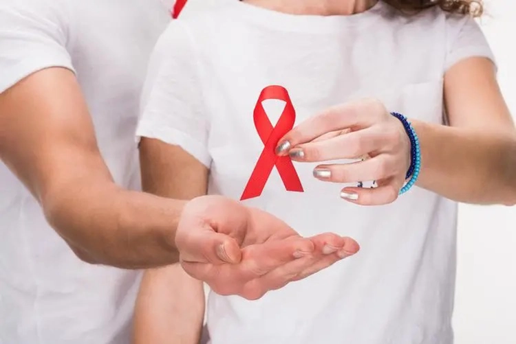 A young woman holds the AIDS Association logo.