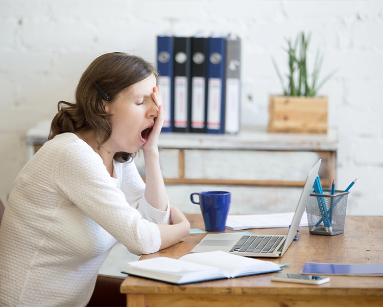 The girl at work yawns because of lack of sleep.