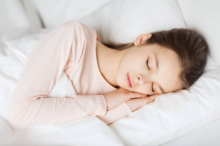 A young girl rests her eyes and rests her mind on the white bed.