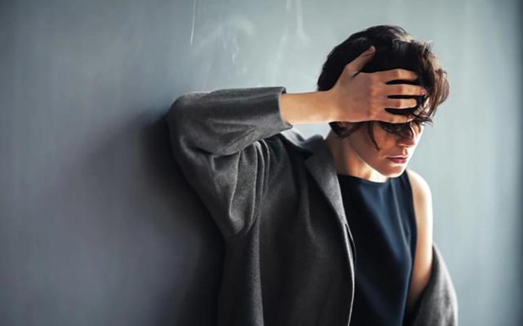 Ze leunde tegen de muur met één hand ter ondersteuning van haar hoofd