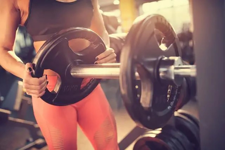 Elle fait des exercices anaérobiques sur la barre. - Squats avec poids