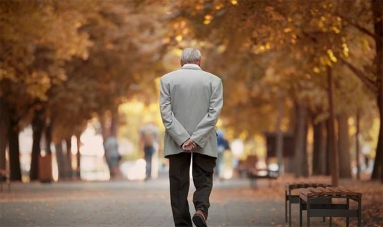 Le vieil homme marchait sur la route d'automne.