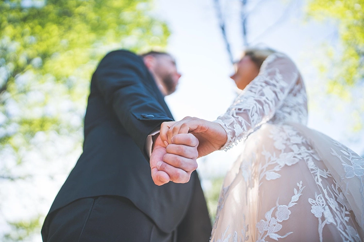 Elle lui tenait la main dans une robe de mariée et se regardaient